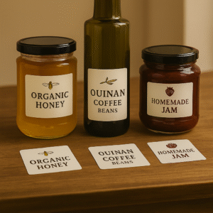 Glass jars and a bottle with custom square product label stickers for honey, coffee beans, and jam – PixiLand Studios Graphics.