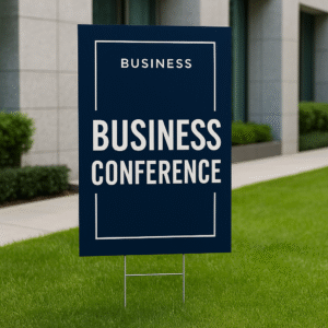 Vertical business conference yard sign on grass outside a modern office building